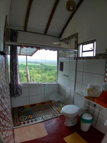 łazienka z toaletą i dużym oknem w obiekcie Aldeia Canastra Pousada w mieście São Roque de Minas