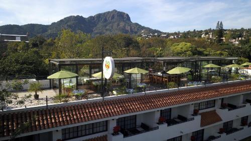 a building with tables and chairs and umbrellas at Hotel Las Puertas de Tepoztlan in Tepoztlán