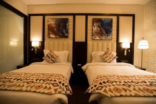 a hotel room with two beds and two lamps at Ramada by Wyndham Kapurthala in Kapūrthala