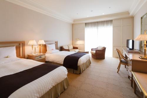 um quarto de hotel com duas camas e uma secretária em Okura Akademia Park Hotel em Kisarazu