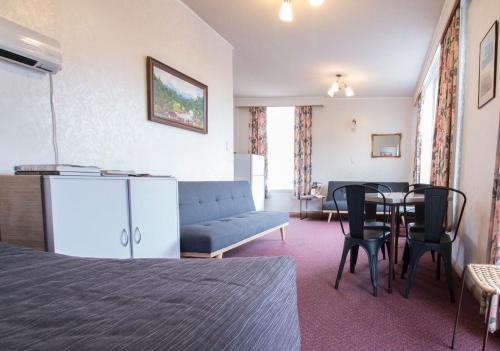 una camera d'albergo con letto, tavolo e divano di Masonic Hotel a Palmerston North
