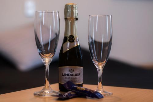 a bottle of champagne and two glasses on a table at Masonic Hotel in Palmerston North