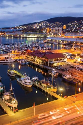 a marina with boats in the water at night at Hotel Grand Chancellor Hobart in Hobart