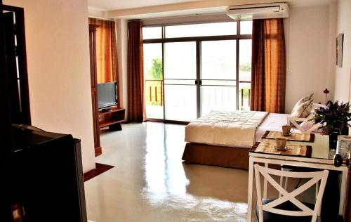 a hotel room with a bed and a tv and a television at The Meet Green Apartment in Bangkok