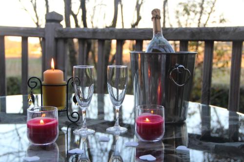 einen Tisch mit Weingläsern, eine Flasche und Kerzen in der Unterkunft Cabane d'Amour in Béziers