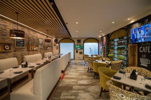 a restaurant with white tables and yellow chairs at Ramada by Wyndham Kapurthala in Kapūrthala