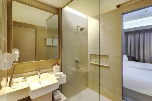 a bathroom with a sink and a shower at Swiss-Belhotel Cirebon in Cirebon