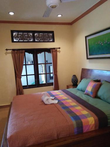 un dormitorio con una cama con un gato sobre ella en Wirya House, en Ubud