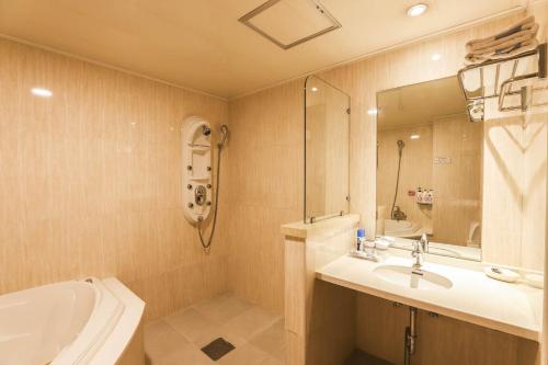 a bathroom with a sink and a toilet and a tub at Amour Hotel in Suwon