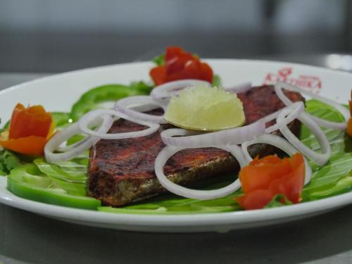 ein Teller mit Essen mit Fleisch und Gemüse darauf in der Unterkunft KARTHIKA RESIDENCY in Kilimanūr