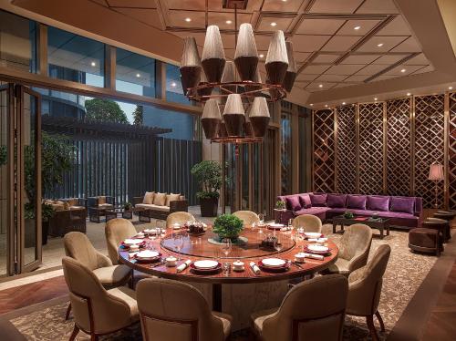 a large dining room with a table and chairs at New World Guiyang Hotel in Guiyang