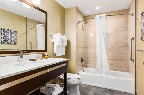 a bathroom with a tub and a toilet and a sink at Best Western Plus Philadelphia-Pennsauken Hotel in Cherry Hill