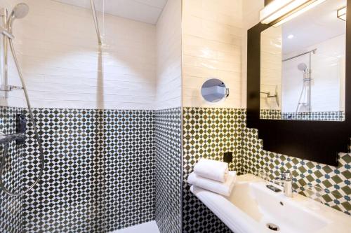 a bathroom with a sink and a shower at Best Western Hôtel Journel Paris Sud in Ris-Orangis