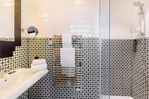 a bathroom with a shower and a sink and a tub at Best Western Hôtel Journel Paris Sud in Ris-Orangis