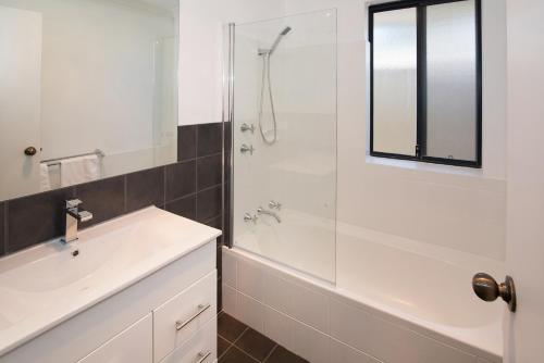 baño blanco con ducha y lavamanos en Tootys Place en Margaret River Town