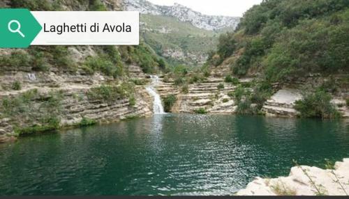 a river with a waterfall in the middle of a mountain at Il sentiero del mare in Avola