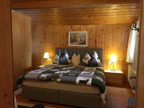 ein Schlafzimmer mit einem Bett in einem Holzzimmer in der Unterkunft Haus Natalie in Bartholomäberg