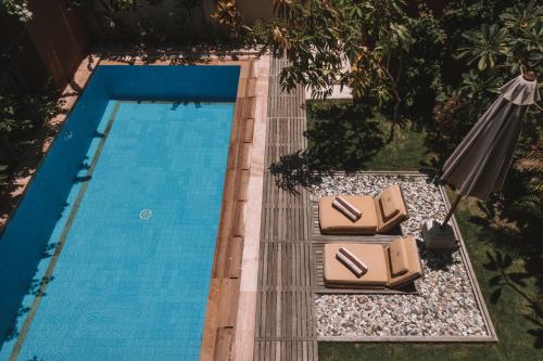 an overhead view of a swimming pool with chairs and an umbrella at Apalagi Villas in Gili Air
