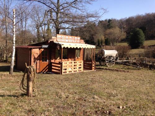a small wooden building in a field with a wagon at Voyage Spatio-Temporel in Poussanges