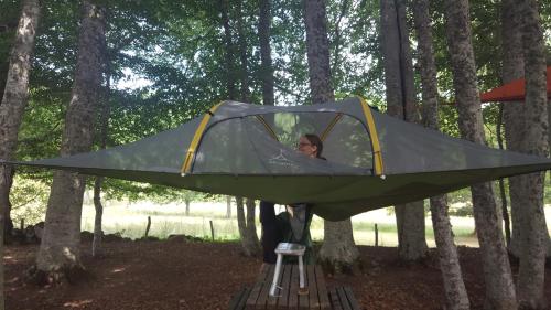 a woman in a tent in the woods at Voyage Spatio-Temporel in Poussanges