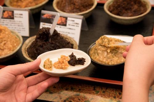 a person reaching for a plate of food on a counter at Kyo no Minshuku Ohara no Sato in Kyoto
