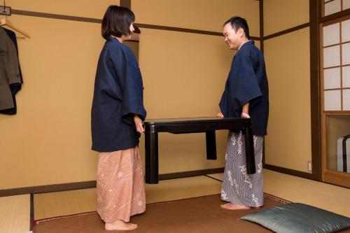 two people in kimonos standing in a room at Kyo no Minshuku Ohara no Sato in Kyoto