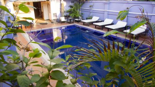 una piscina con un montón de sillas alrededor en Champey Villa, en Siem Reap