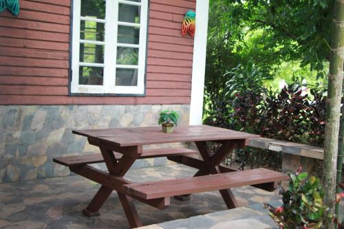 a picnic table and bench outside of a house at River Kwai Park & Resort in Chongsadao