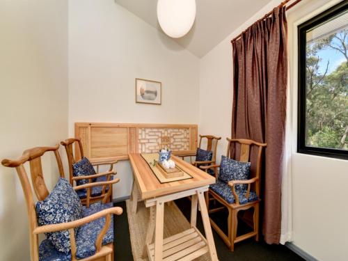 a dining room with a wooden table and chairs at Sinofield Edu-Retreat in Leura