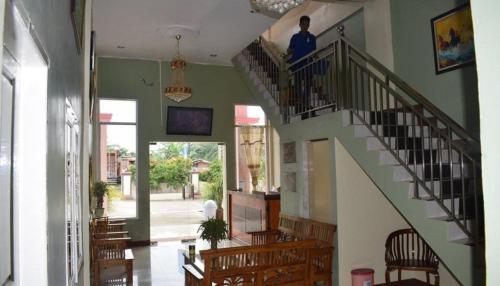 a man is standing on the stairs of a building at Hotel Grand Family in Sungairampah