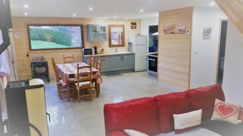 sala de estar con sofá rojo y cocina en Châlet de la Feigne, en Anould