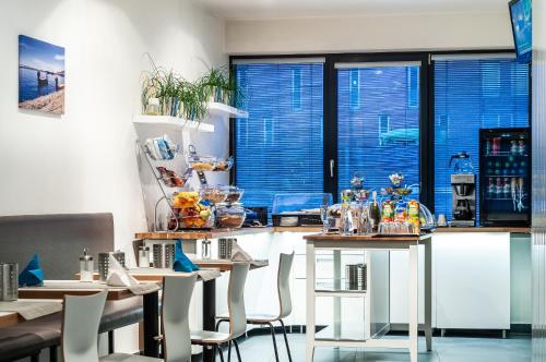 a kitchen with a table, chairs, and a refrigerator at VV hotel & apartments in Brno