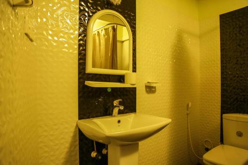 a bathroom with a sink and a mirror and a toilet at Kandyan Hideout in Kandy