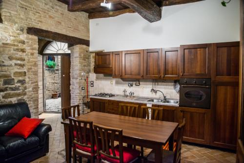 cocina con armarios de madera y mesa de madera en Vecchio Forno Casa Vacanze, en Montefalco