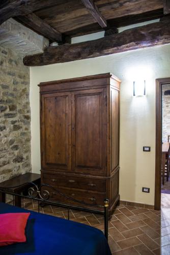 a large wooden cabinet in the corner of a room at Vecchio Forno Casa Vacanze in Montefalco