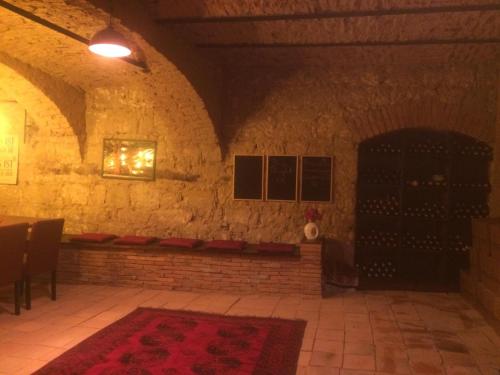 a room with a brick wall with a table and a red rug at Haus Diogenes in Mörbisch am See