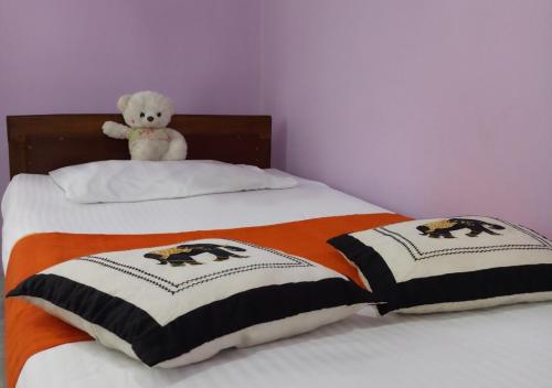 a teddy bear sitting on top of a bed at VILLA CHAND KALUTARA in Kalutara