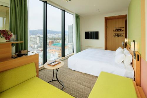 a hotel room with a bed and a large window at Candeo Hotels Hiroshima Hatchobori in Hiroshima