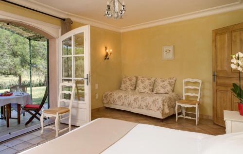 a bedroom with a couch and a table and chairs at Le Mas Des Sables in Aigues-Mortes