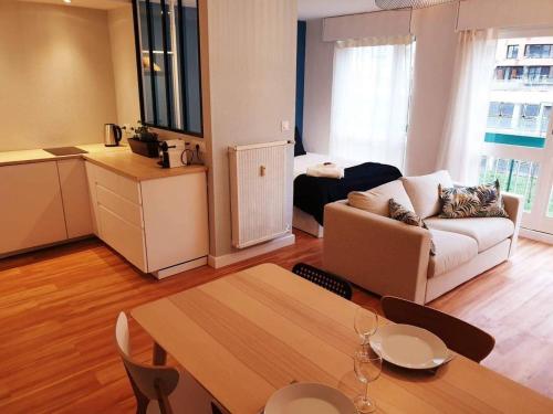 un salon avec une table et un canapé et une cuisine dans l'établissement Cozy Loft Metz Gare, Pompidou, Centre Congres, Muse, à Metz