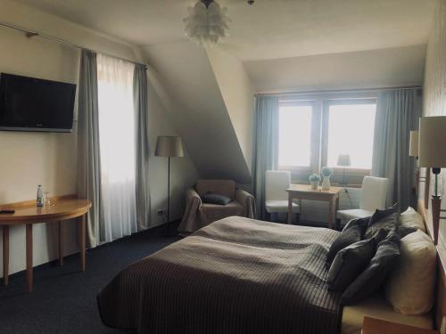Habitación de hotel con cama y sala de estar. en deckert`s Hotel an der Klosterpforte en Lutherstadt Eisleben