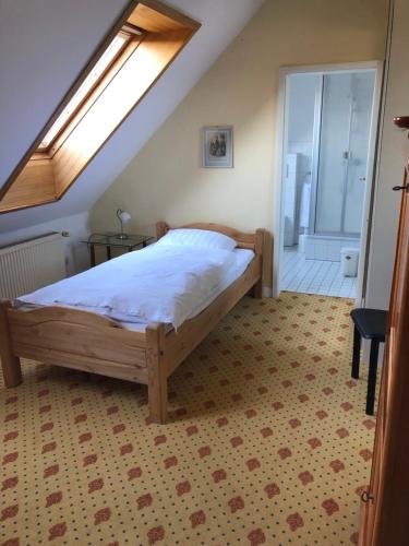 ein Schlafzimmer mit einem Bett und einem Dachfenster in der Unterkunft Hotel Pension Gutshaus Neu Wendorf in Sanitz