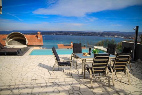 a patio with a table and chairs and a view of the water at Liams Mansion in Koper