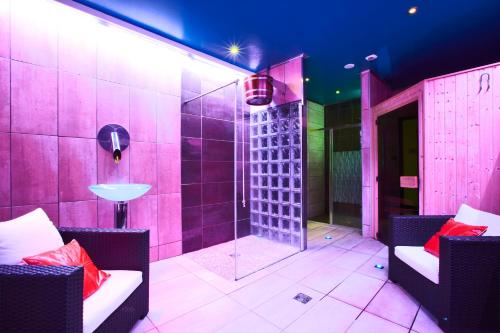 a pink bathroom with a shower and a sink at Enzo Hotels Reims Tinqueux by Kyriad Direct in Reims