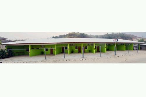a large green building with a roof at IRIS MOTEL in Tachilek