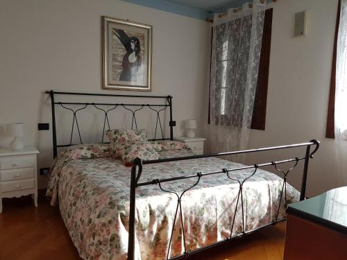 サン・ドナ・ディ・ピアーヴェにあるCa l'oasiのベッドルーム1室(ブラックメタルフレームのベッド1台付)