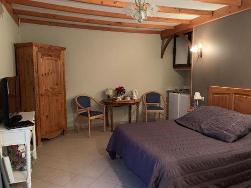 1 dormitorio con 1 cama, mesa y sillas en Les Charmilles, en Hazebrouck