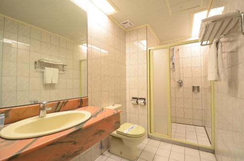 a bathroom with a sink and a toilet and a shower at 爵起商務飯店 in Taoyuan
