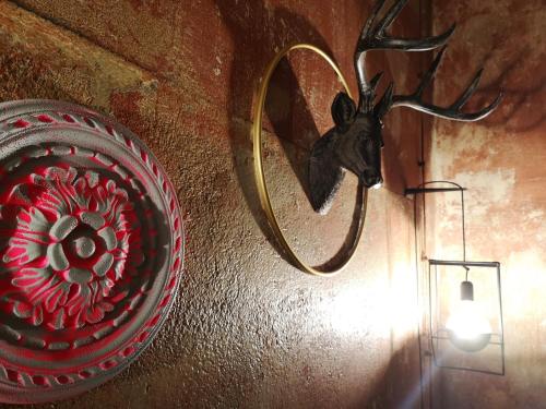 a red vase with a deer head on a wall at Zeit Hotel in Līgatne