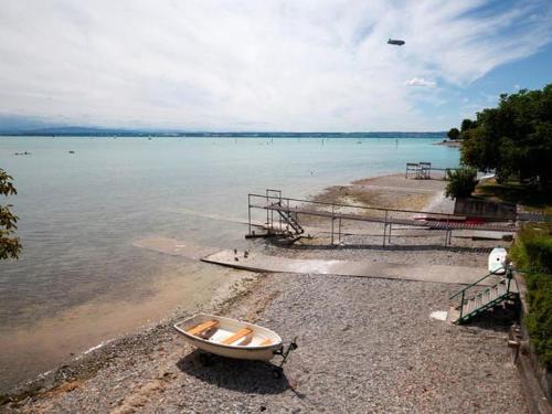 a boat sitting on the shore of a beach at Gästehaus am Bodensee in Immenstaad am Bodensee